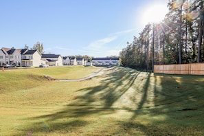 A residential area with houses, a grassy slope, and a wooden fence. - Rebel Retreat - Close to the Square, Campus and MTrade Park! (Oxford)