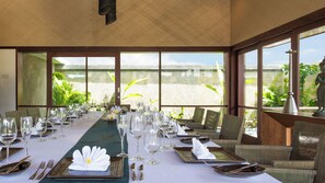 A long dining table set for a meal with clear glassware, plates, and cutlery, overlooking a scenic view. - Bayu Gita Beachfront - 6BR Oceanfront Villa, Cinema, Gym & Huge Pool (Bali)