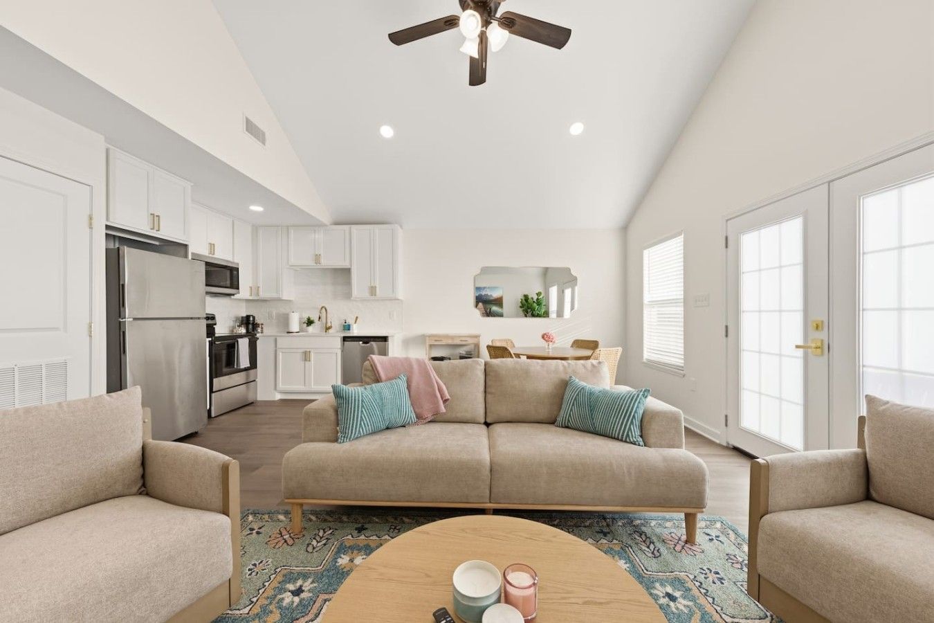 A spacious living room with a beige sofa, a coffee table, and a ceiling fan.