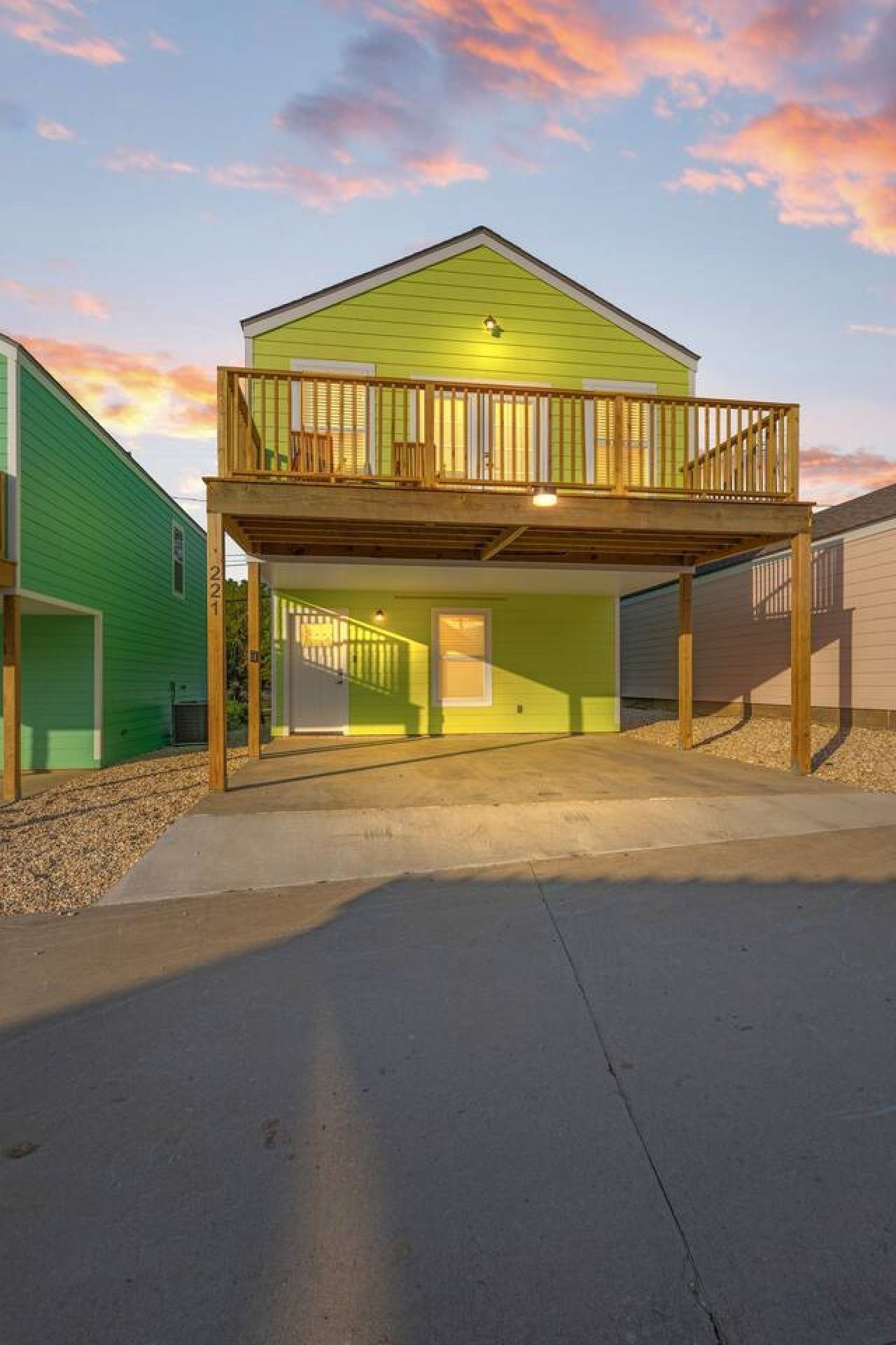 A two-story house with a balcony, a garage, and a driveway.