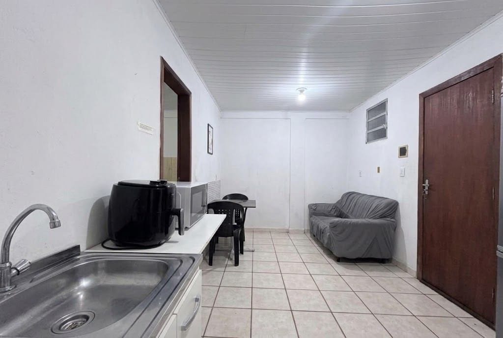 A compact kitchenette with a sink, a coffee maker, and a small table.