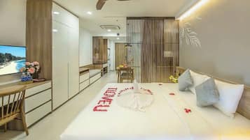 A modern hotel room with a bed, a desk, and a TV.