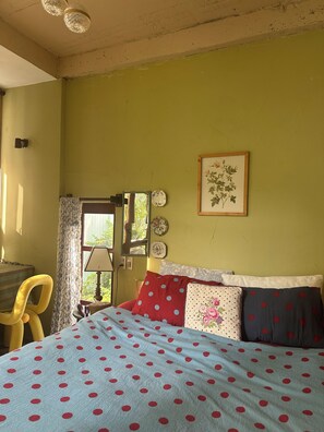 A bedroom with a bed, a chair, a window, and a door. - Cozy 1-bedroom cottage in peaceful Thanh Khê with AC (Thanh Khê)
