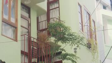 Un edificio de varios pisos con balcones, ventanas y vista a la calle.