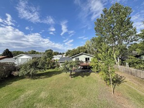 A residential area with houses, a grassy yard, and trees.