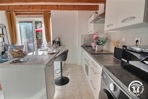 A modern kitchen with a central island, white cabinetry, and a black countertop. - La Noë - LA MEAUGON - Vacation Rental (LA MEAUGON)
