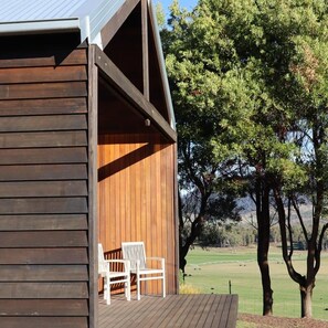 A wooden building with a porch and two white chairs. - Villa Rochford Kellevie (Sorell)