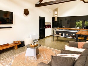 A modern living room with a flat-screen TV, a coffee table, and a sofa. - Villa Rochford Kellevie (Sorell)