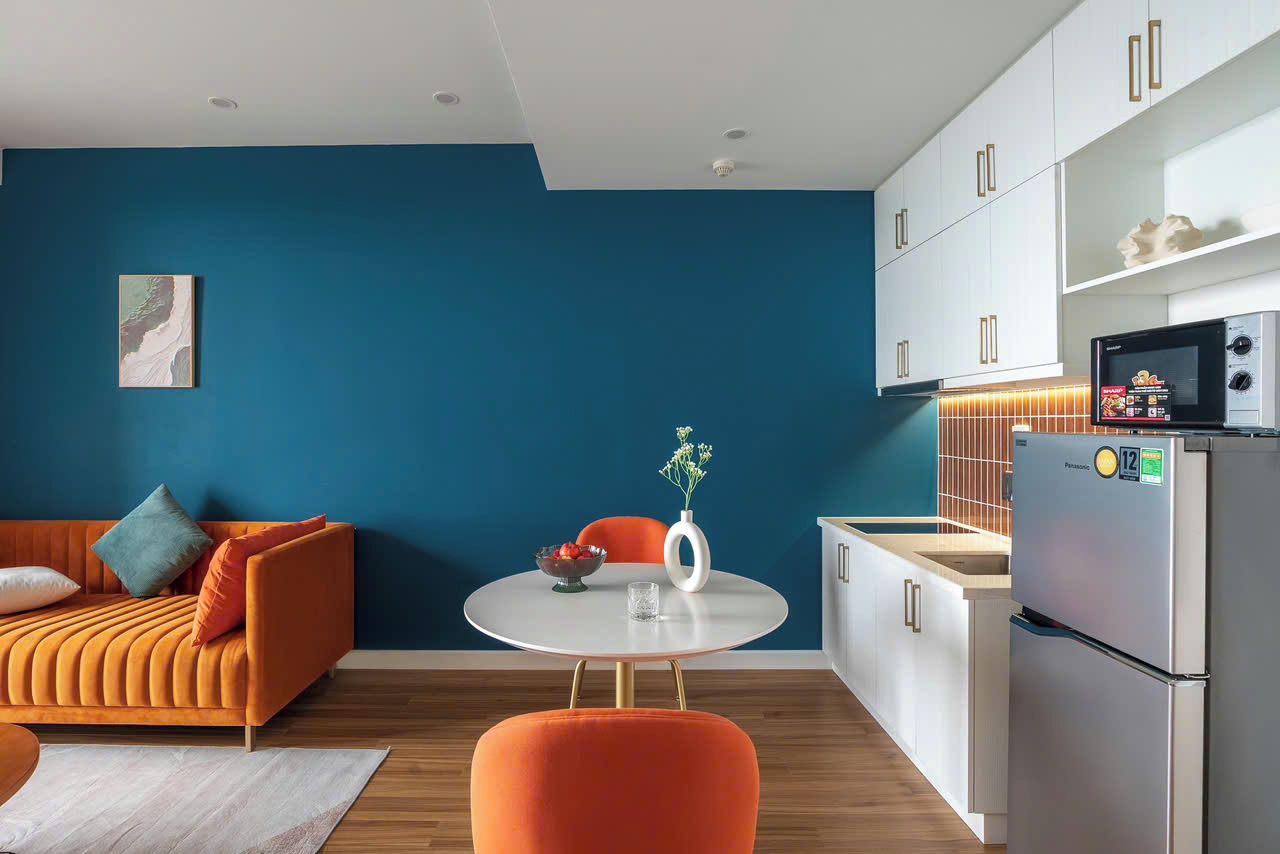 A modern kitchen with white cabinets, a stainless steel refrigerator, and a microwave.