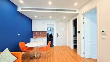 A modern interior with a dining area, kitchen, and a blue accent wall.