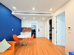 Un interior moderno con comedor, cocina y una pared de acento azul.