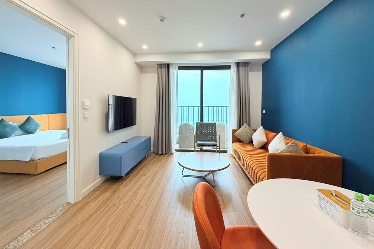 Una habitación de hotel con cama, sofá, mesa de comedor y televisor.