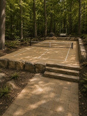 A tennis court surrounded by stone steps and a forested area. - Private 1BR Mountain Cabin with Hot Tub & Forest Views (Menlo)