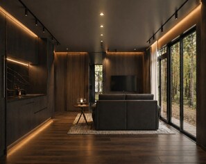 A modern interior with a wooden floor, a sofa, a TV, and a large window. - Private 1BR Mountain Cabin with Hot Tub & Views (Menlo)