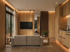 A modern interior with a sofa, TV, and wooden cabinets. - Private 1BR Mountain Cabin with Hot Tub & Views (Menlo)