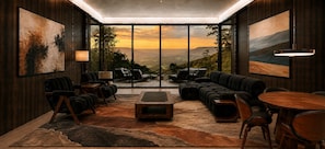 A modern lounge with a large window offering a scenic view, plush seating, and a central coffee table. - Private 2BR Mountain Cabin with Hot Tub & Views (Menlo)