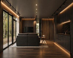 Een modern interieur met een bank, een flatscreen televisie en een keukenhoek.