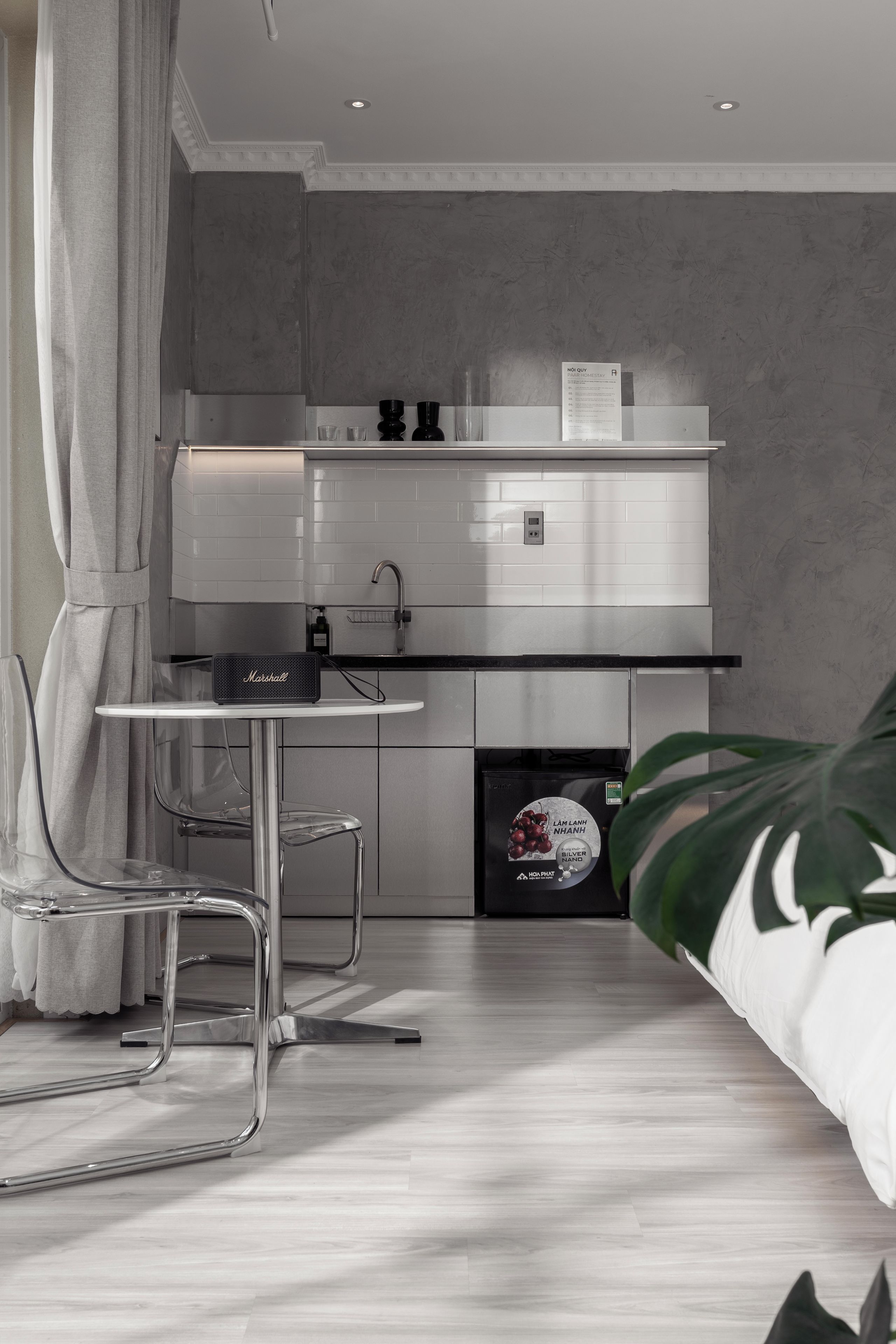 A modern kitchen with a built-in oven, a coffee machine, and a refrigerator.