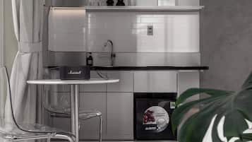 A modern kitchen with a built-in oven, a coffee machine, and a refrigerator.