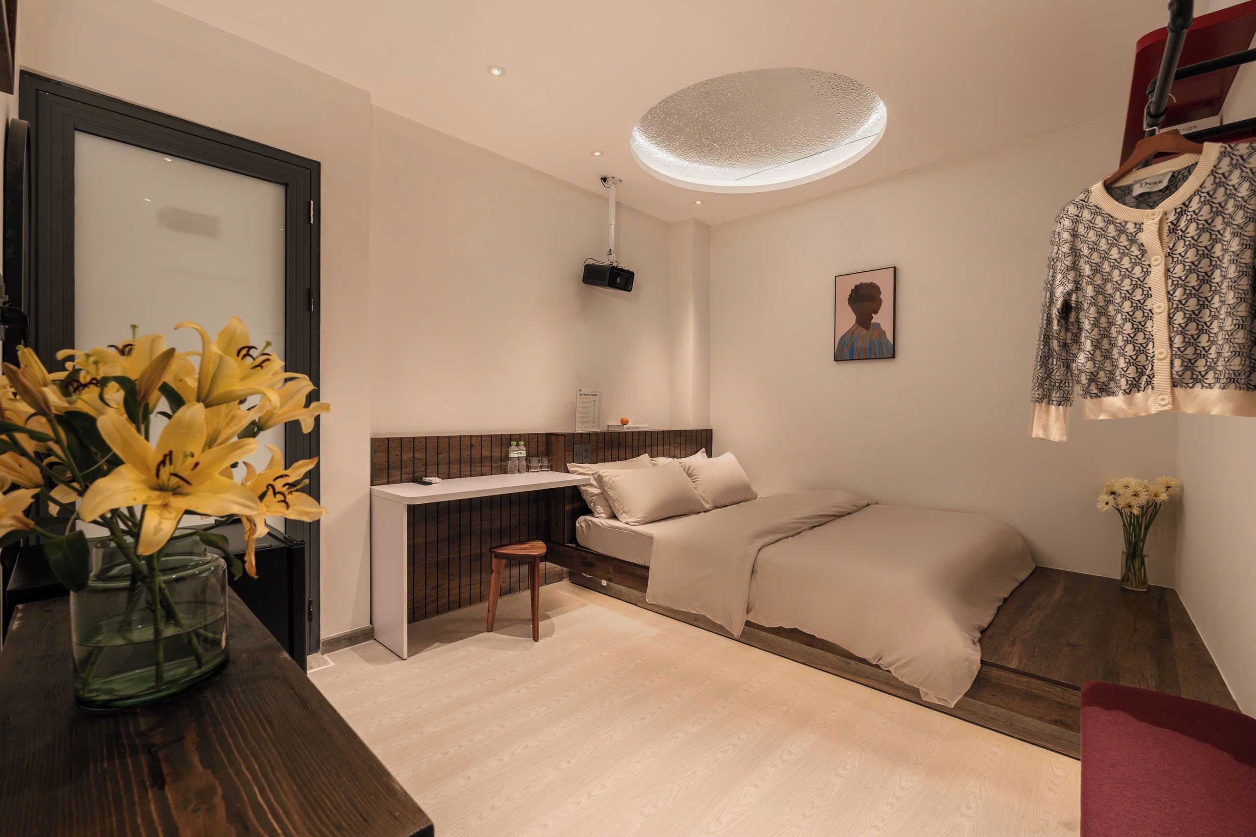 Un dormitorio moderno con cama, mesita de noche y espacio de escritorio.