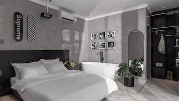 A modern bedroom with a large bed, a built-in bathtub, and a wall-mounted projector.