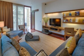 A modern living room with a sofa, a television, and a bookshelf. - Casa Brio - Private Chef Villa for 8 till 10, Floating Breakfast, Seminyak (Bali)