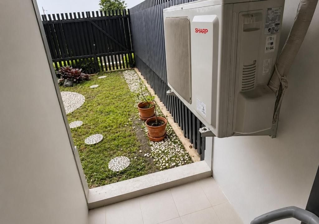 A small outdoor garden area with a paved pathway, potted plants, and a black fence.