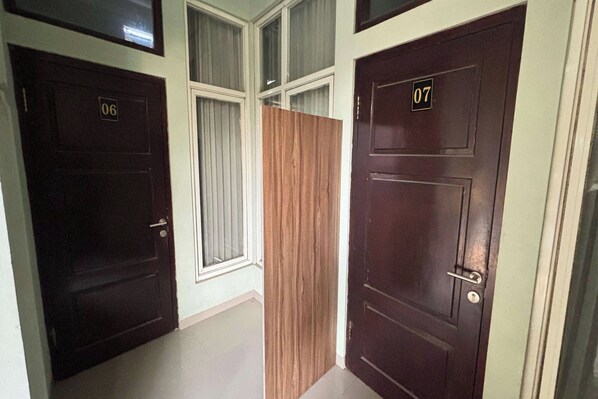 A hallway with two dark wooden doors, each marked with a number.