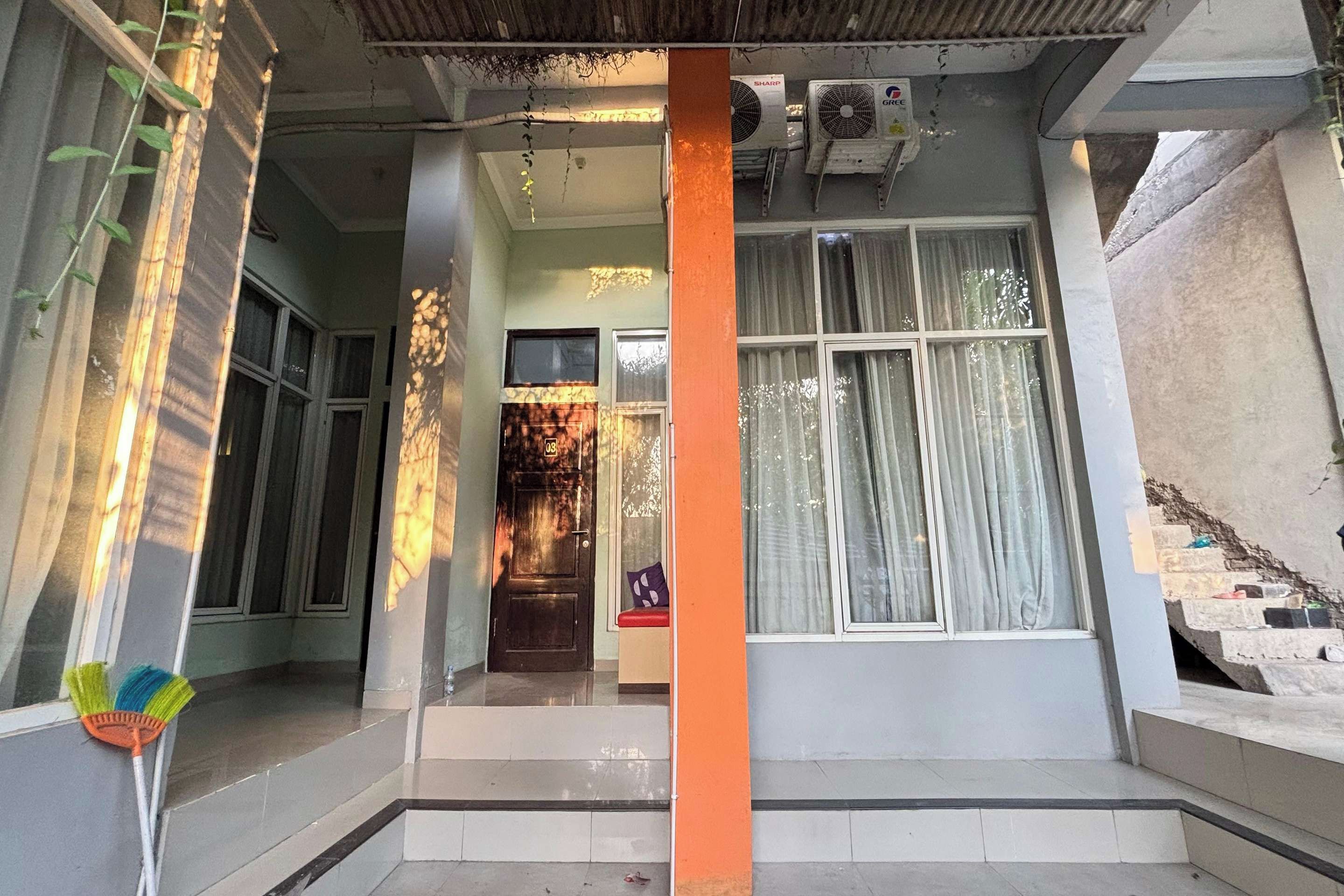 A residential entryway with a staircase leading to a door marked with the number 08.