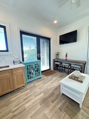 A modern kitchen with wooden cabinets, a teal cabinet, and a white countertop. - Cozy studio in walking distance to restaurants, marinas, coffee shop & groceries (Marsh Harbour)