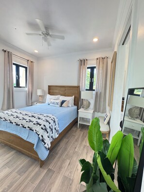 A bedroom with a bed, bedside tables, a chair, and a ceiling fan. - Cozy studio in walking distance to restaurants, marinas, coffee shop & groceries (Marsh Harbour)