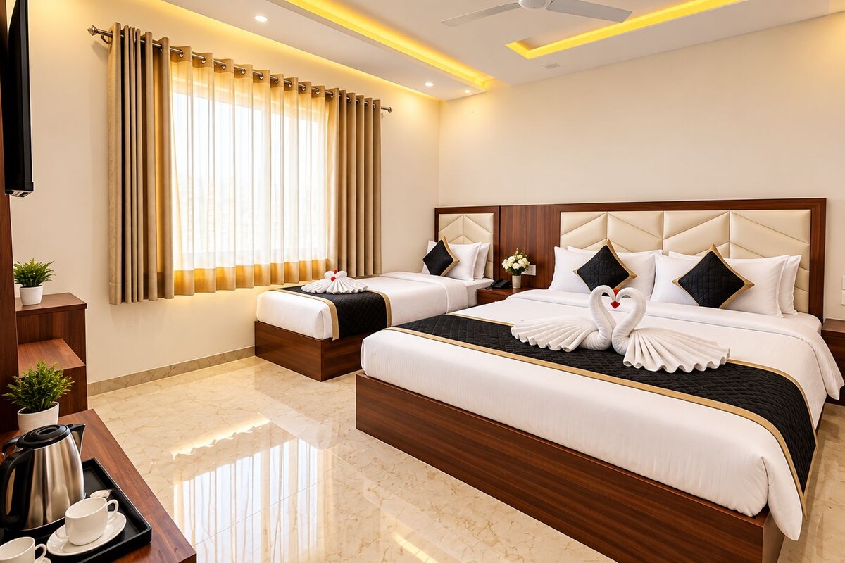 A hotel room with two beds, a desk with a kettle, and a large window with curtains.