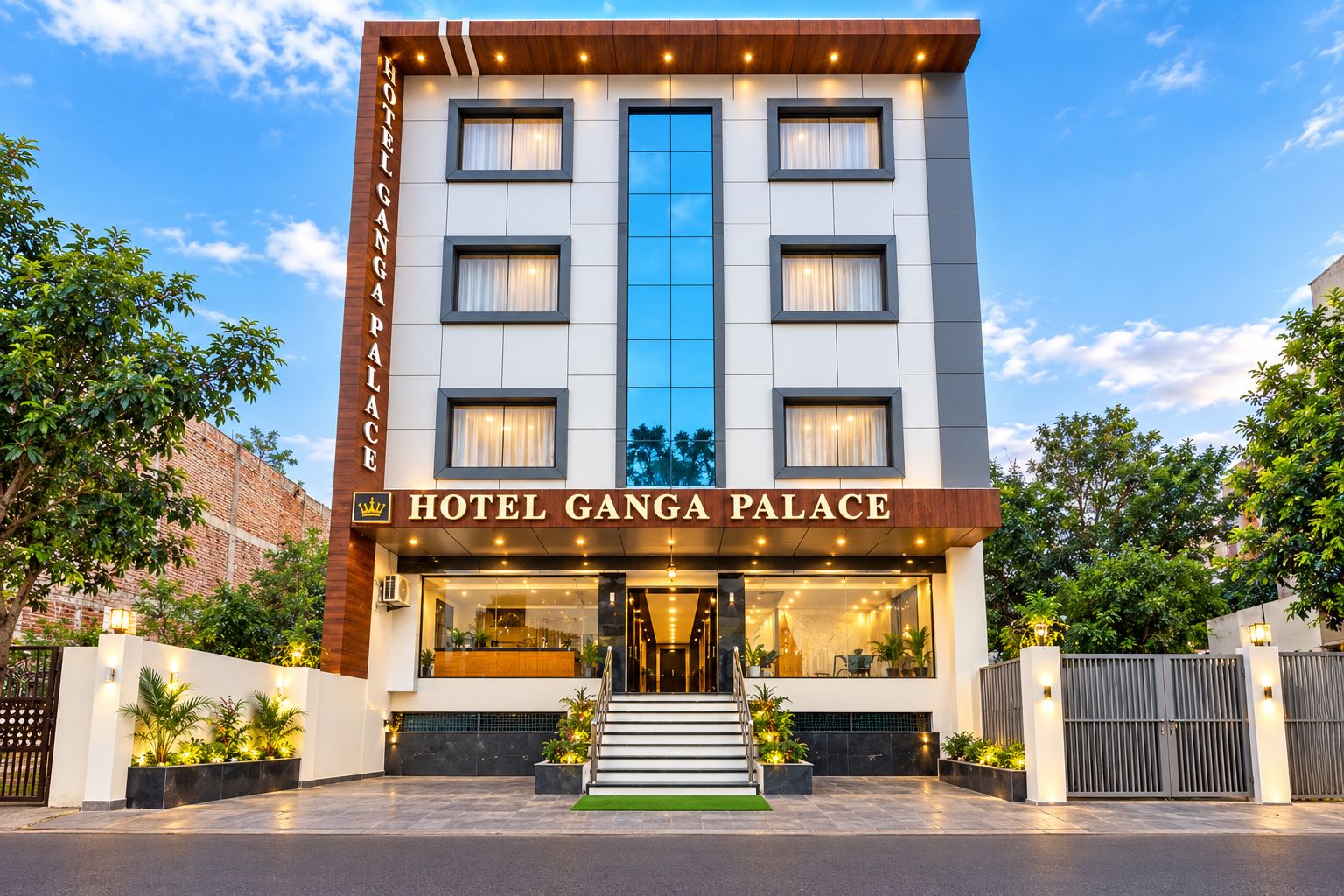 A multi-story hotel with a prominent entrance, a sign reading 'HOTEL GANGA PALACE,' and a staircase leading to the entrance.