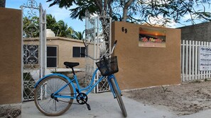 Ein blaues Fahrrad vor einem verschlossenen Eingang mit einem Schild, das auf einen Verleihservice hinweist.