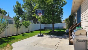 A residential backyard with a basketball hoop, a grill, and a fenced yard. - Beautiful 5-bedroom house with a beautiful mountain views. (North Ogden)
