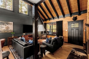 A cozy cabin interior with a fireplace, leather sofas, and a television. - 8 min to Breck DT•Steps to Stream•Hottub/Sauna (Breckenridge)