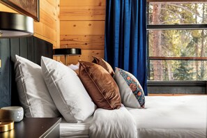 A bedroom with a wooden headboard, a bedside table with a lamp, and a window with curtains. - 8 min to Breck DT•Steps to Stream•Hottub/Sauna (Breckenridge)