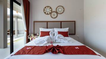 A hotel room with a bed, a view of the outdoors, and decorative wall art.