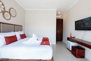 Una habitación de hotel con una cama grande, televisión y un armario de madera.