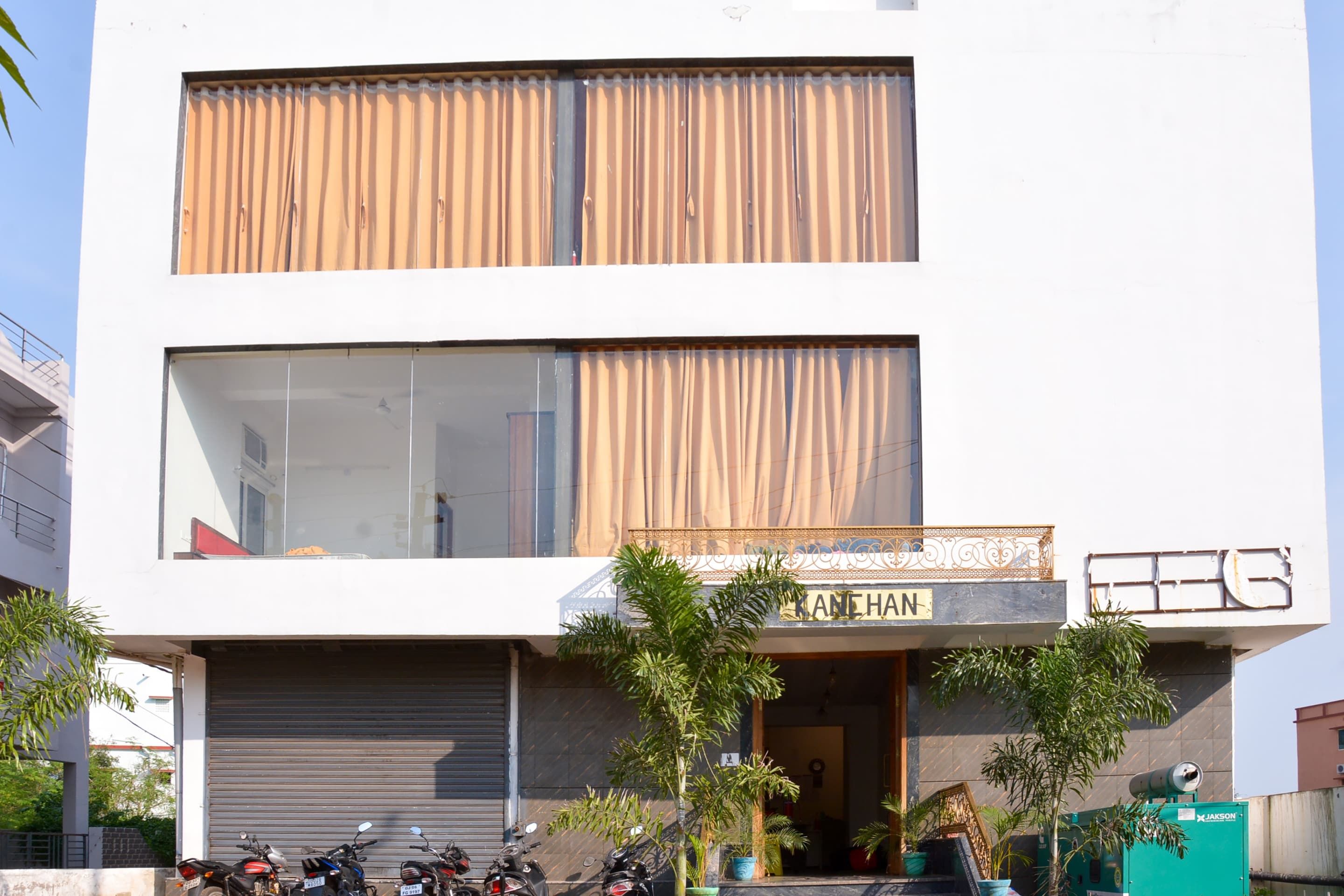 Un edificio de dos pisos con un letrero que dice 'KANEHAN' en la planta baja.