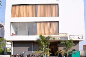 Un edificio de dos pisos con un letrero que dice 'KANEHAN' en la planta baja.