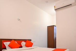 Una habitación de hotel con cama, armario y aire acondicionado.