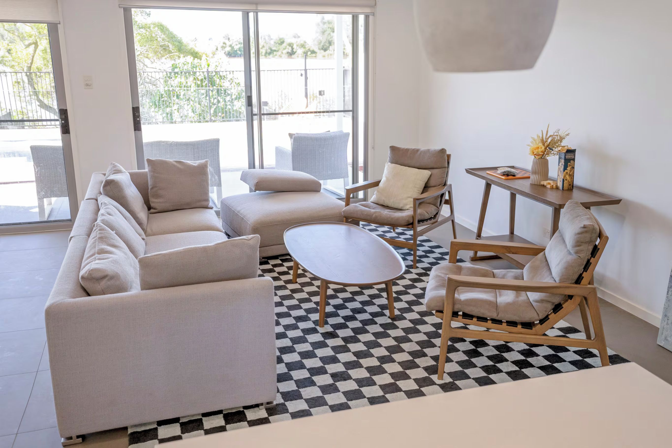 A modern living room with a checkered floor, a sofa set, a coffee table, and a chair.