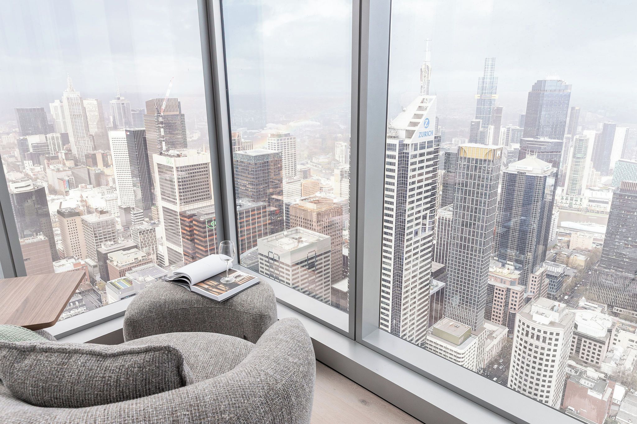 A high-rise room with a large window overlooking a cityscape.