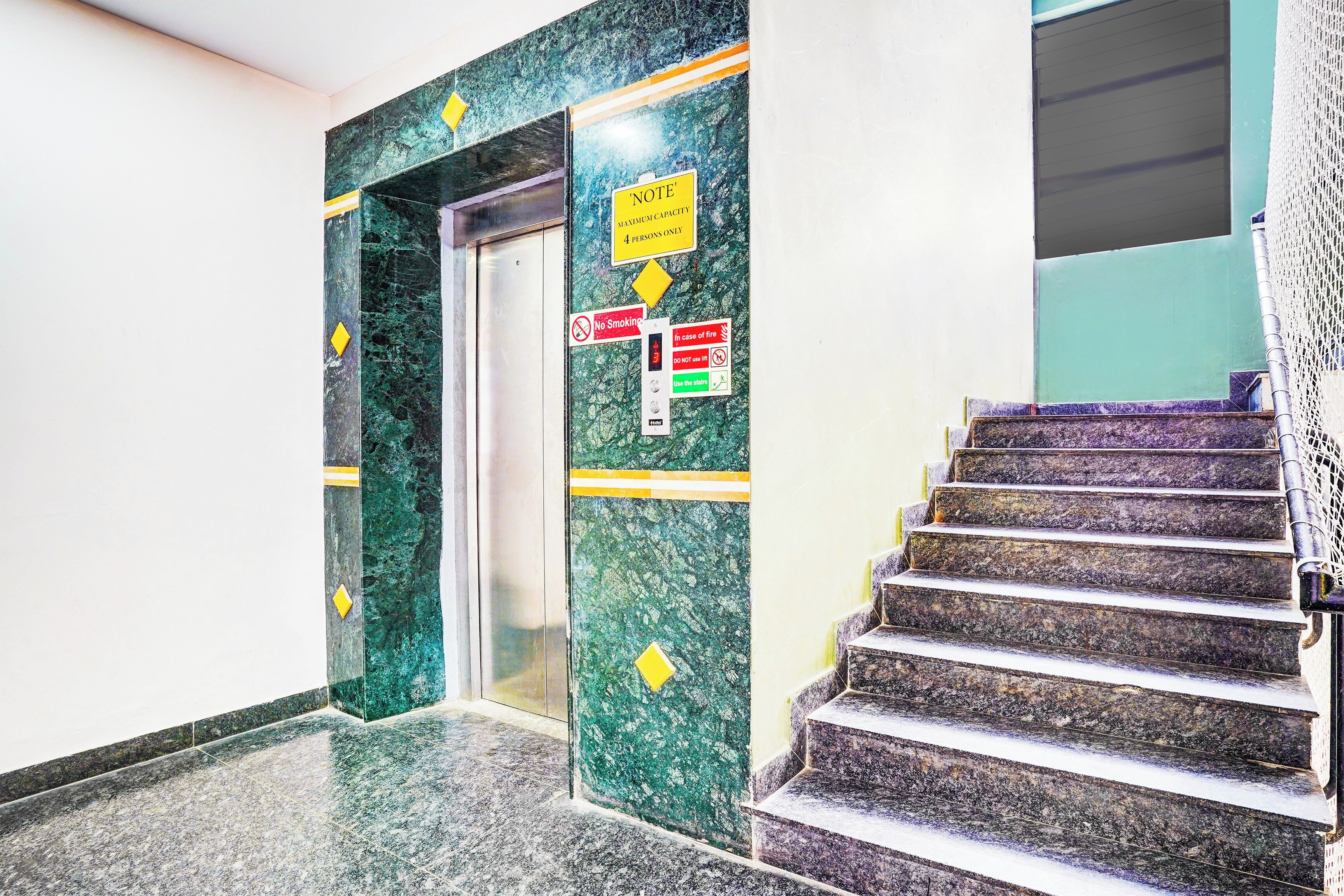 Un ascensor con un cartel que indica una capacidad máxima de 4 personas.