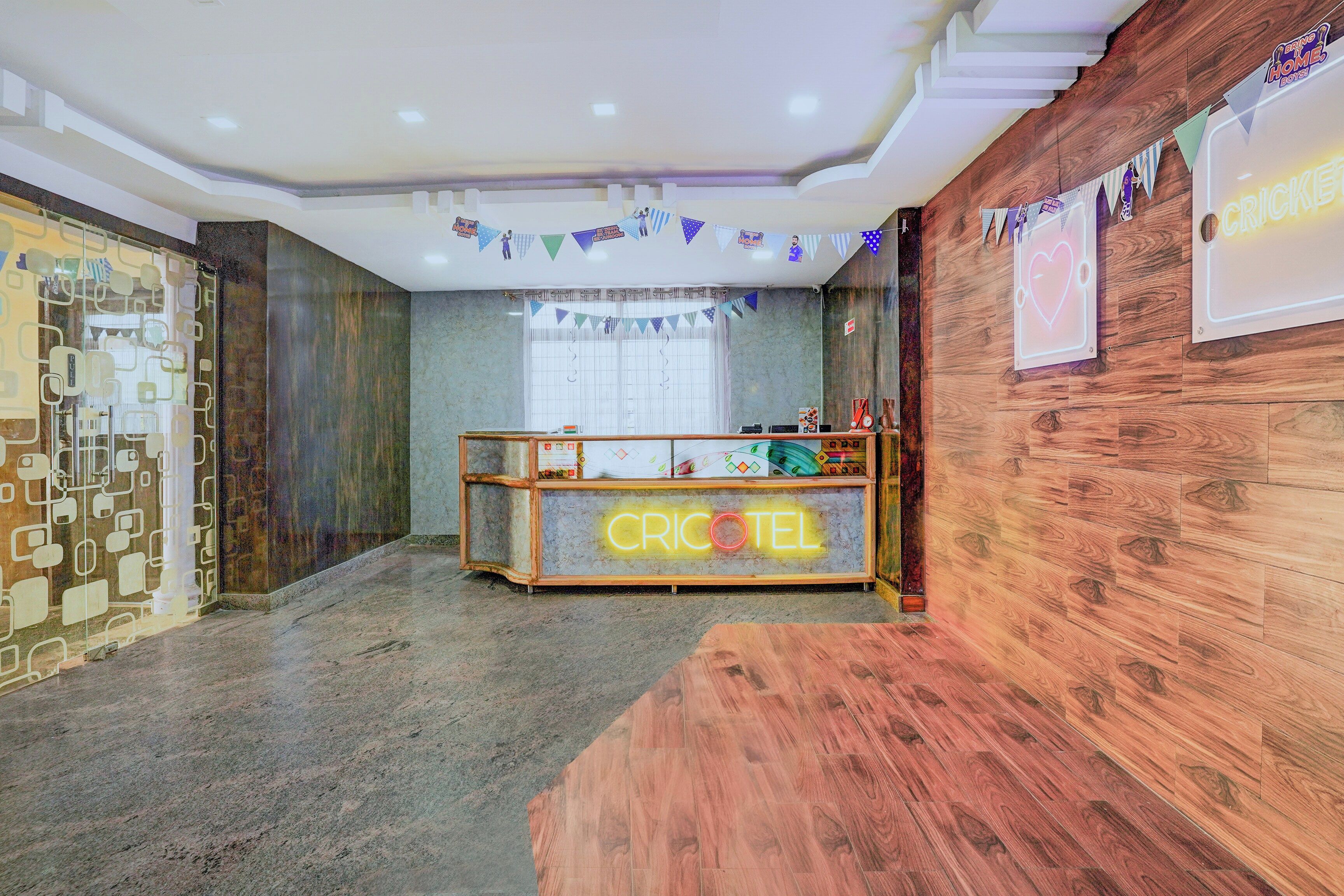 Una zona de recepción con un mostrador de madera que muestra 'CRICKET' y un letrero de neón.