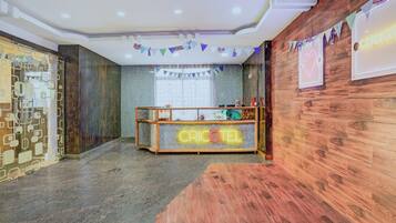 Una zona de recepción con un mostrador de madera que muestra 'CRICKET' y un letrero de neón.