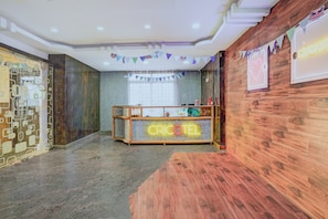 A reception area with a wooden counter displaying 'CRICKET' and a neon sign.
