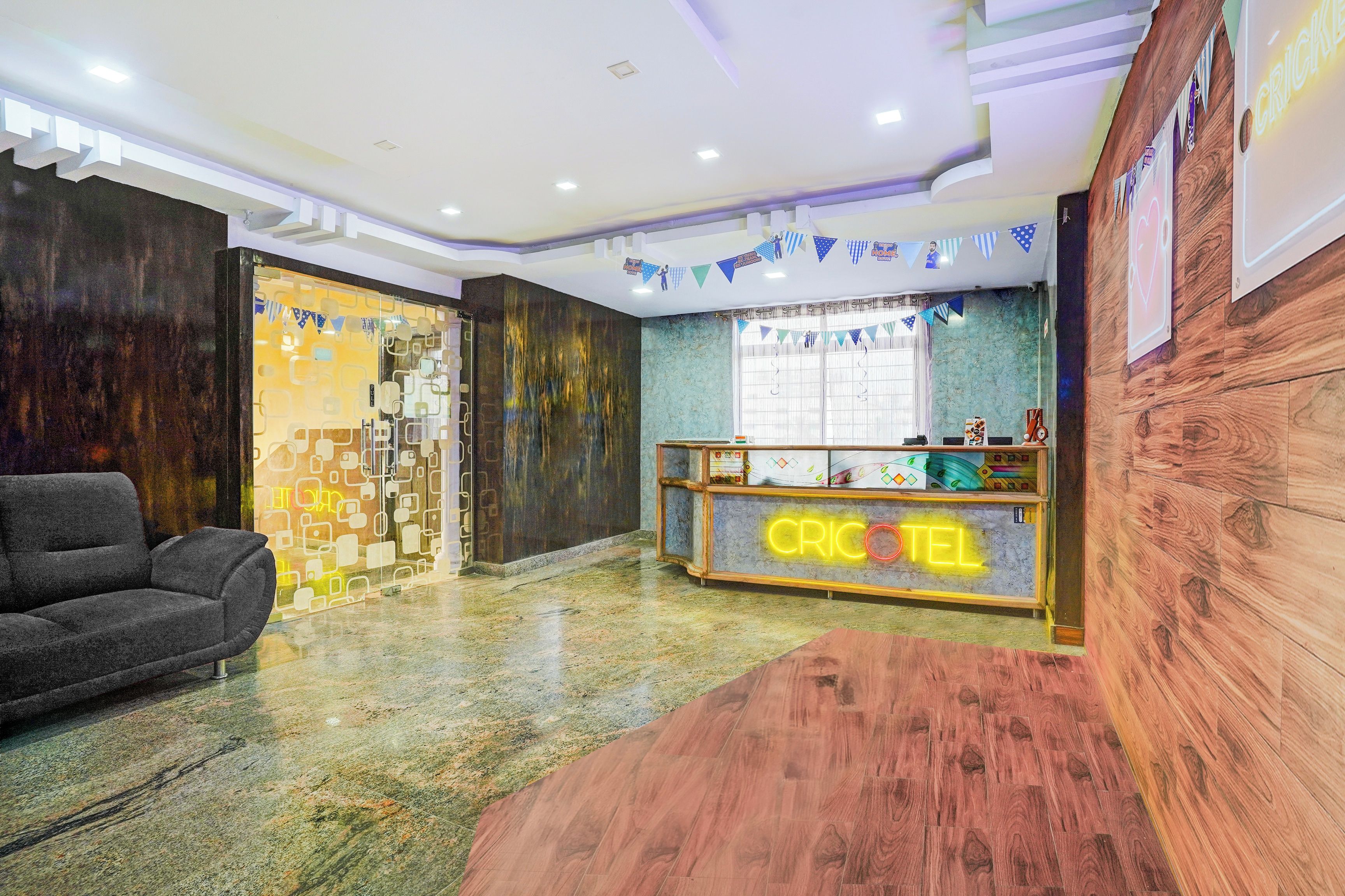 Un área de recepción con un mostrador de madera identificado con 'CRICKET' y un sofá gris.