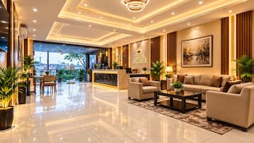 Una hall d'albergo con reception, zona salotto e vista sulla città.